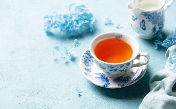 istock Cup of black tea with flowers. Blue background. Copy space. Close up. 2188247573