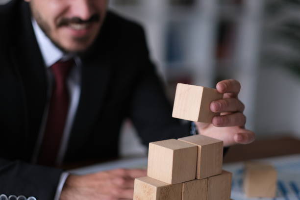 istock Businessman building tower with wooden blocks 2188248501