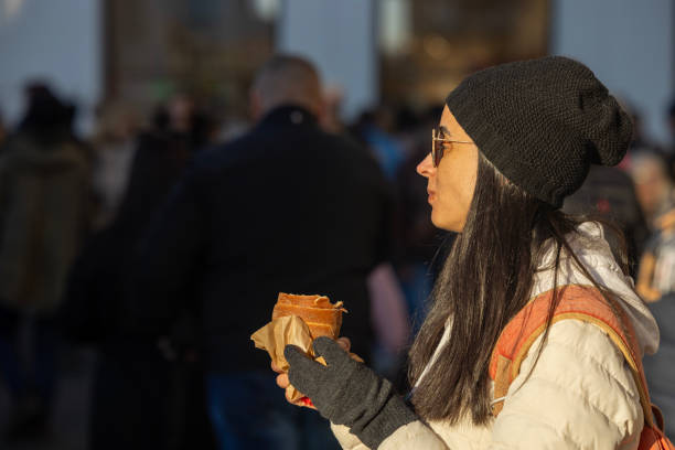 A solo traveler woman explores Amsterdam in springtime, enjoying local food and drinks, capturing memories with selfies, and embracing the joy of discovering a new city.
