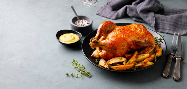 istock Roasted, baked chicken with potatoes and herbs on dark plate. Grey background. Copy space. 2188249344