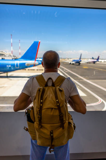 istock Unrecognizable man enjoying view on airport runway from waiting area 2188256299