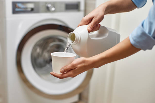 istock Woman pours liquid laundry detergent into plastic cap 2188256608
