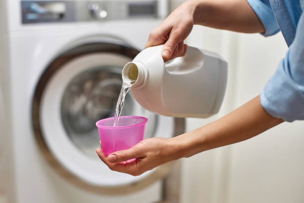 istock Woman pours liquid laundry detergent into plastic cap 2188256609