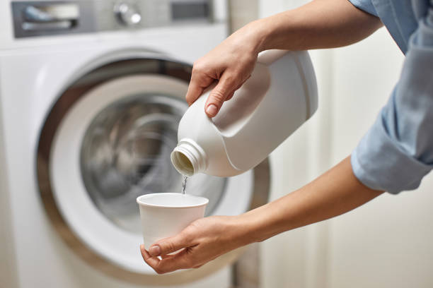 istock Woman pours liquid laundry detergent into plastic cap 2188256610
