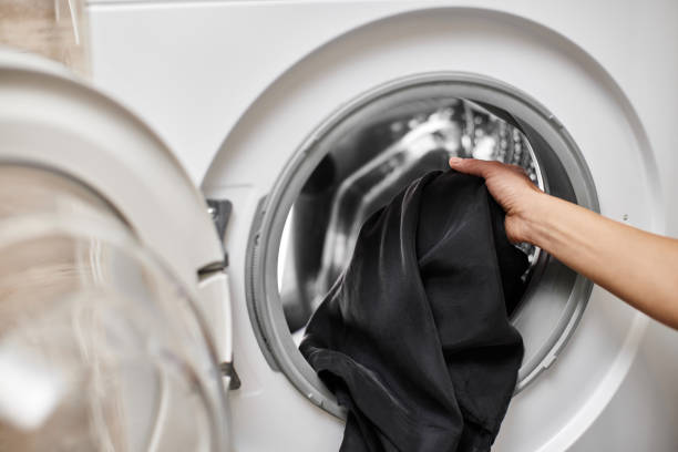 istock Woman putting clothes into the washing machine 2188256615