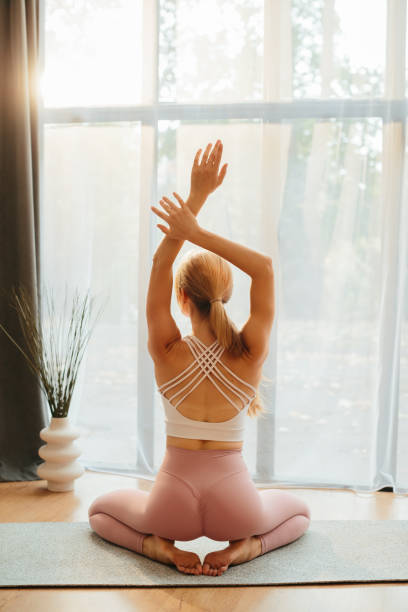 istock Athletic blonde doing flexibility stretches near a floor-to-ceiling window in a modern studio 2188263393