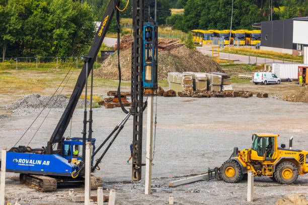 Sweden. Uppsala. 08.05.2024. Construction site with heavy machinery including pile driver and yellow loader in industrial area. Sweden. Uppsala. 08.05.2024.