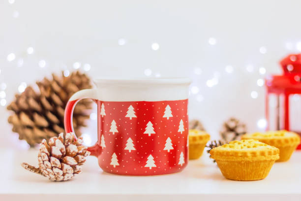 istock red mug with Christmas trees and mini cakes with snowflake and pine cone on table 2188270792