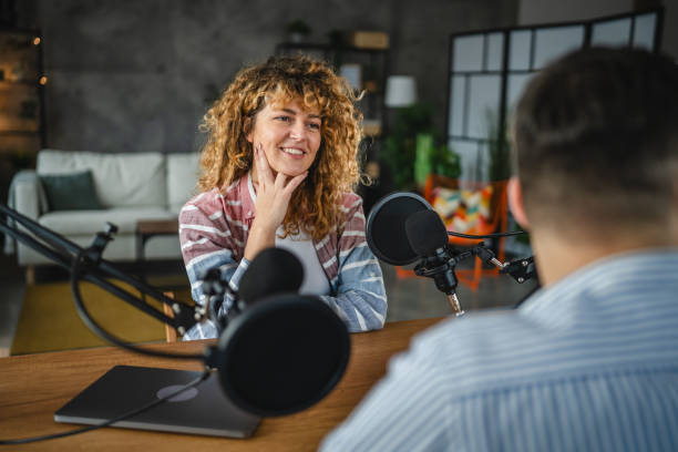 istock woman host interviewer ask man guest questions while record podcast 2188276922