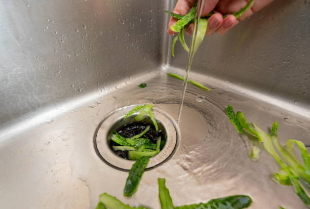 istock Cucumber peels directed into a disposer under running water for efficient and eco-friendly kitchen waste disposal. 2188278231
