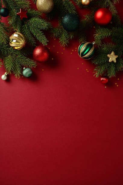 istock Christmas tree branches with vibrant baubles on vertical red background. Perfect for holiday marketing, greeting cards, and seasonal backgrounds 2188278577