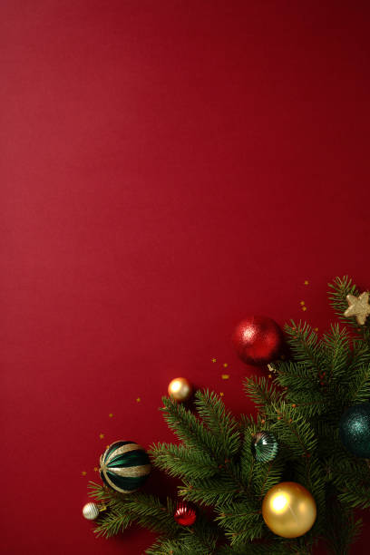 istock Christmas scene with vibrant baubles and pine tree branches on a rich red background. Ideal for seasonal promotions and greetings 2188278605