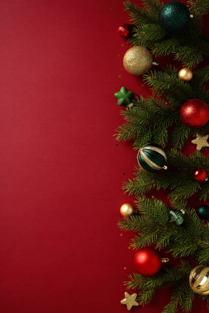 istock Festive Christmas Tree Decorations: Red backdrop with a Christmas tree adorned with green, red, and gold baubles, lights, and ornaments. Perfect for holiday season designs and greetings 2188278663