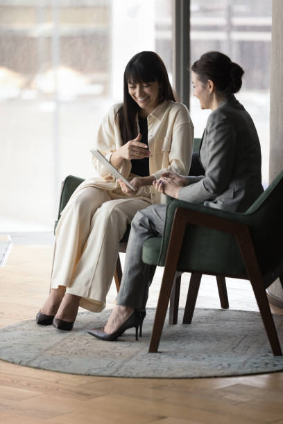 istock Businesswomen laughing, discuss on-line project using digital tablet device 2188278681