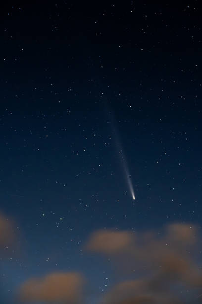 istock Comet shining in the night sky with stars and clouds 2188285719