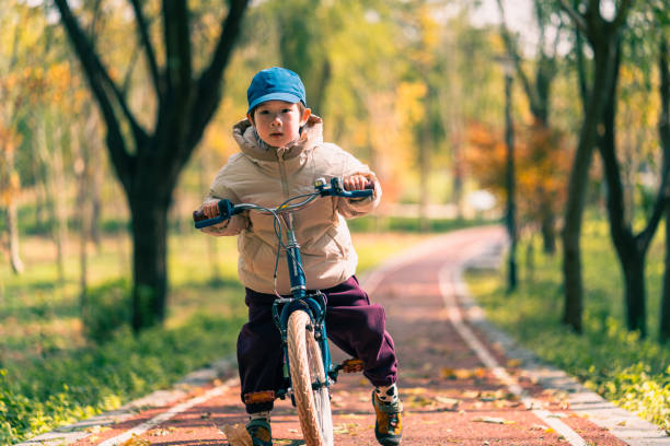 a lovely 5-years-old Chinese boy learns to ride a bike