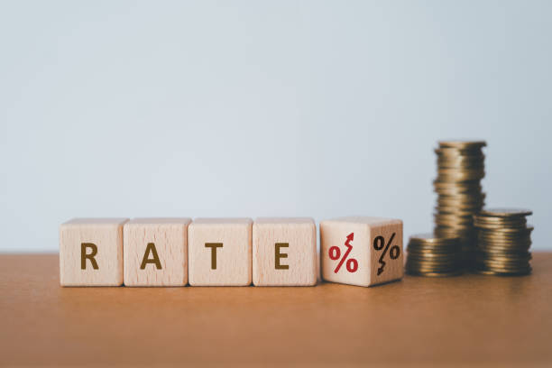 istock RATE text with up and down percent on wooden cube blocks and blurred stack of coins including copy space 2188287317