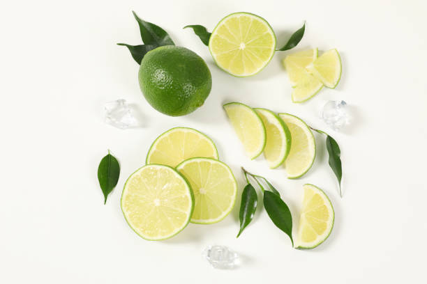 istock Fresh limes, ice and green leaves on white background, flat lay 2188287445