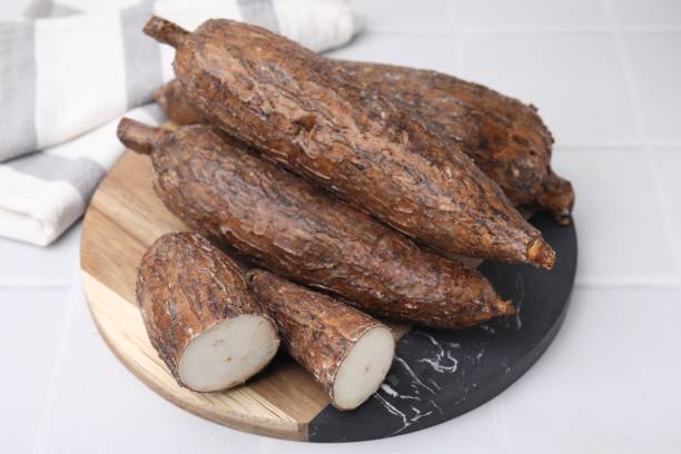istock Whole and cut cassava roots on white tiled table 2188287552