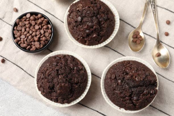 istock Tasty chocolate muffins and cloth on table, flat lay 2188287793
