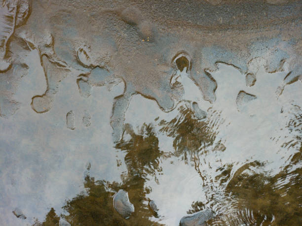 istock A serene close-up of water rippling over a sandy surface 2188301053