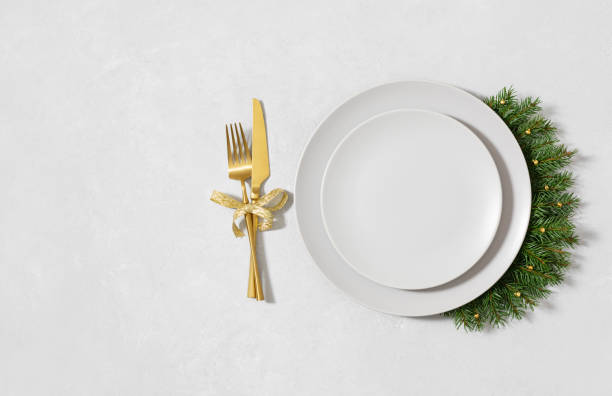 istock Christmas table setting with beige empty plate, fir branches and golden cutlery on white background. New Year serving for a festive dinner. Copy space. Directly above. 2188307120