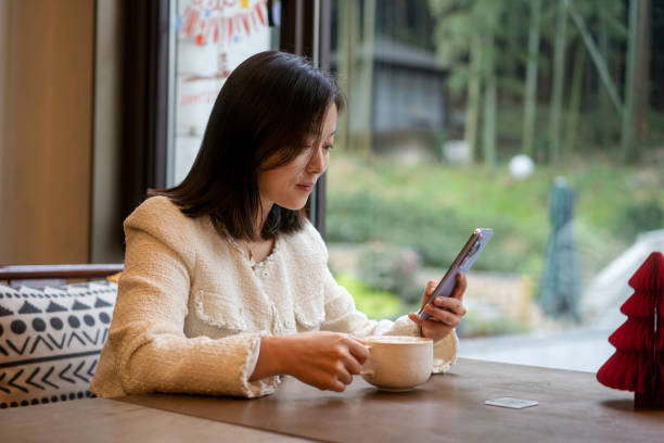 istock asian female using smart phone in coffee shop 2188309234