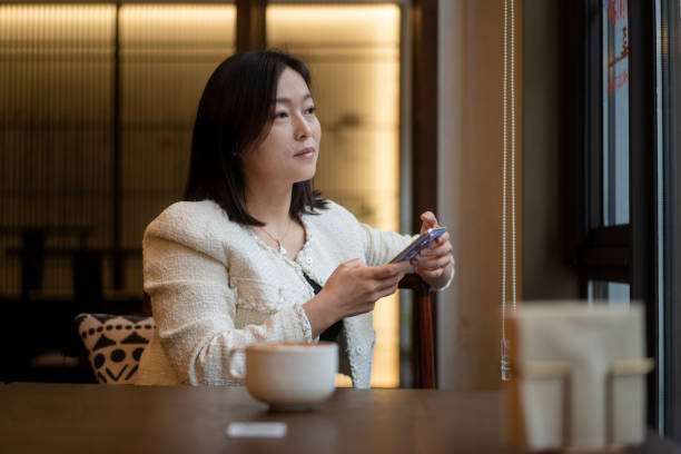 istock asian female using smart phone in coffee shop 2188309252