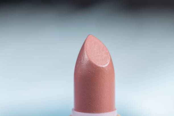 lipstick on a blue background closeup, details of a new open lipstick for makeup
