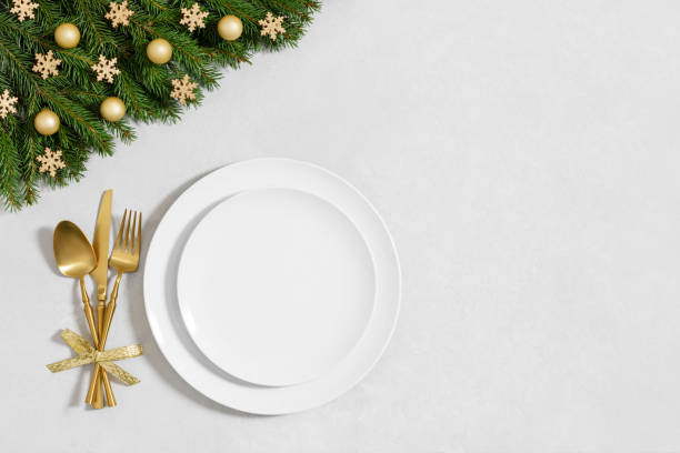 istock A white empty plate with fir branches and festive decorations on white background with copy space. Festive table setting for Christmas dinner. Directly above. 2188312643