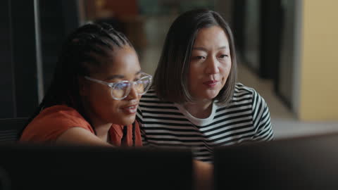 Computer programmers collaborating on software development project in modern office