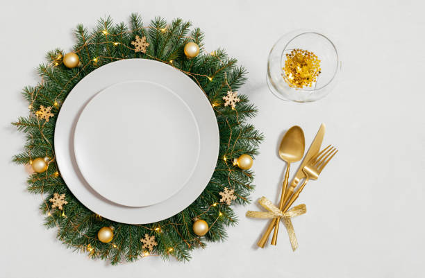 istock Christmas table setting with gold accessories on white background with copy space. Empty beige plate for design. Happy new year. Top view, flat lay. 2188315834