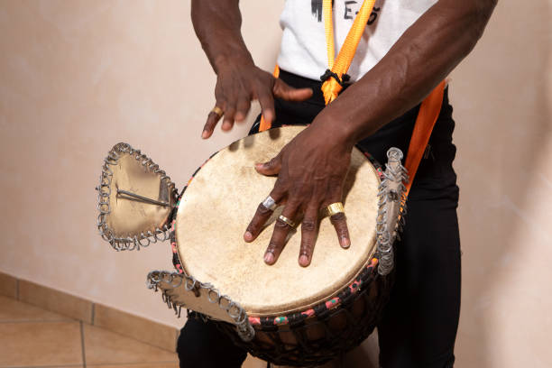 istock Musician playing talking drum with metal rings and orange straps 2188319201