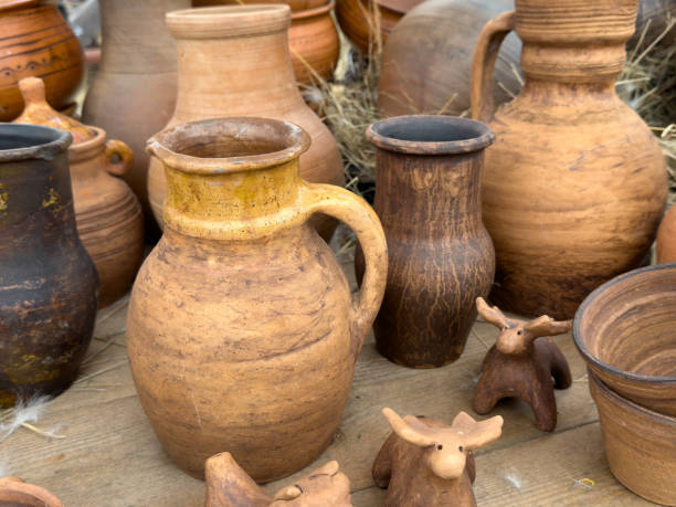 A collection of pottery, including a pitcher and a few other vases, sit on a table