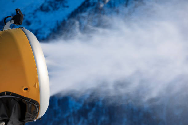snow cannons in full operation at a ski resort producing artificial snow for skiing and snowboarding activities