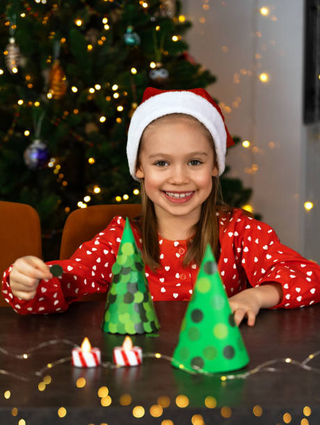 istock Girl make diy Christmas tree from paper. Decorations for New Year. Craft 2188321180
