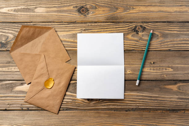 istock Vintage envelope with empty card, pen on wooden table top view 2188322483