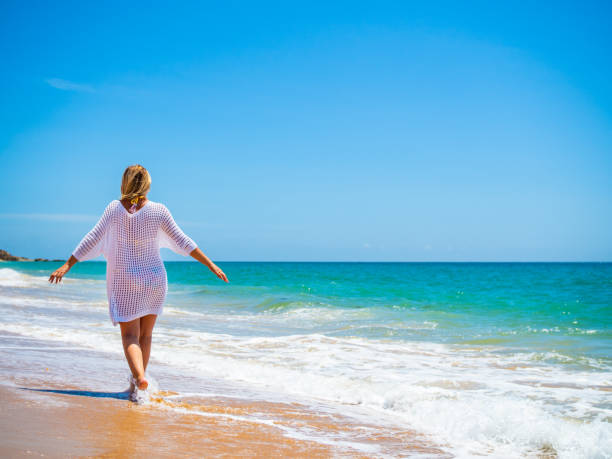 istock Beautiful mature woman walking on beach 2188323153