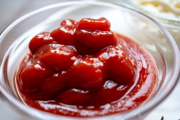 istock pouring ketchup into small glass container in restaurant 2188327297