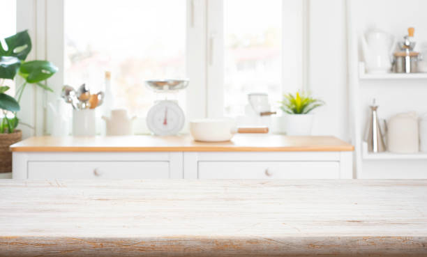 istock Bleached wooden table top background on blur rustic kitchen window interior background 2188328324