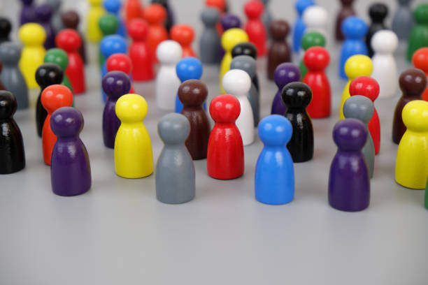 istock Many different colored wooden people figures on gray background. 2188328447