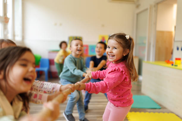 istock Cheerful kids pulling a rope in playroom 2188329996