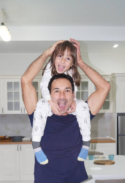 Dad carries his daughter on his back and having fun. High quality photo
