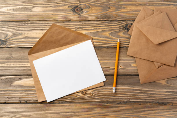 istock Vintage envelope with empty card, pen on wooden table top view 2188330863