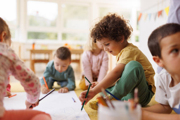 istock Boy drawing whit his friends in kindergarten 2188332089