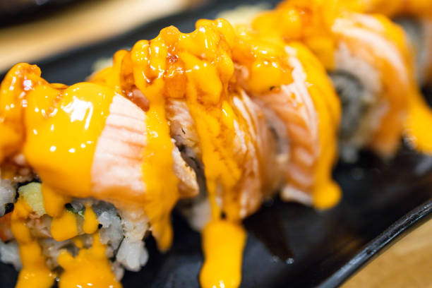 Sushi roll salmon burn with mustard sauce on white isolated.