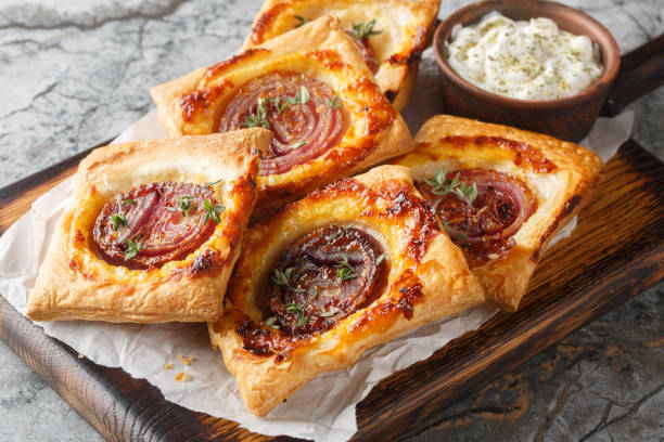 istock Puff mini tarts with caramelized red onion close-up on a wooden board. Horizontal 2188333657