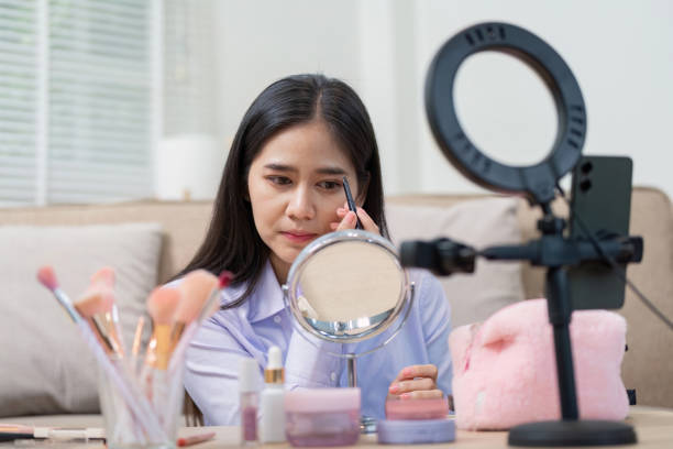 istock Asian woman perfecting eyebrow makeup in home studio 2188335651