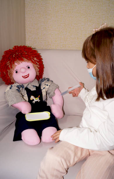 istock little girl makes injection to toy 2188336820