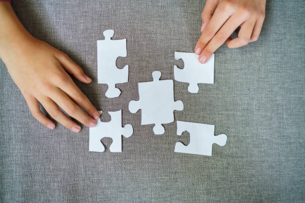 istock The child arranges the puzzle pieces on the table 2188337347